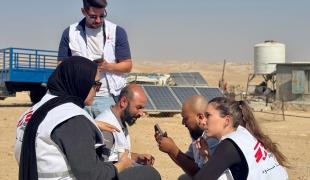 Un coordinateur de terrain de MSF s'entretient avec l'équipe dans la région de Masafer Yatta après avoir reçu un appel signalant une attaque de colons contre la communauté de Sfey, à Masafer Yatta, en Cisjordanie, en Palestine, en 2025.
