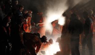 Des secouristes recherchent des survivants coincés sous les débris après le tremblement de terre à Ercis en Turquie.