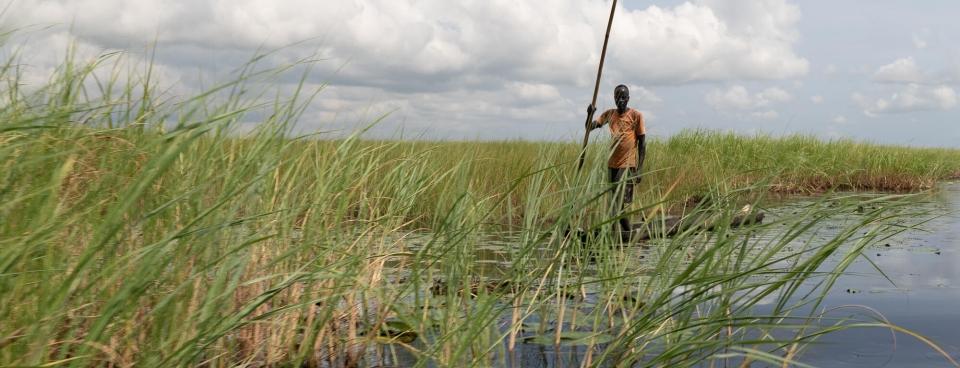 Un homme debout sur un canoë près de la ville d'Old Fangak.